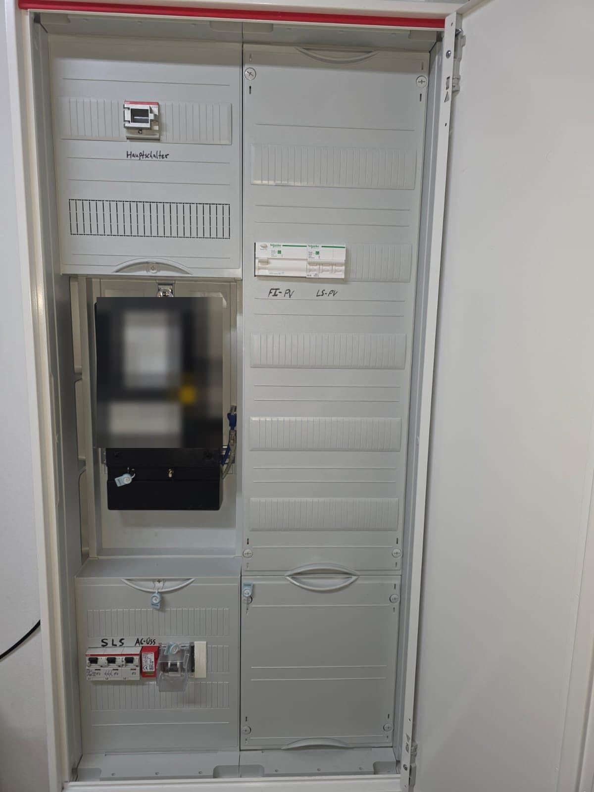 Geöffneter neuer Zählerschrank mit Hauptschalter, Zähler, beschrifteter PV-Absicherung und SLS-Schalter